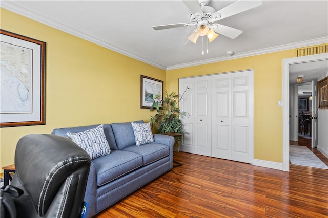 living area with baseboards, visible vents, ceiling fan, wood finished floors, and crown molding