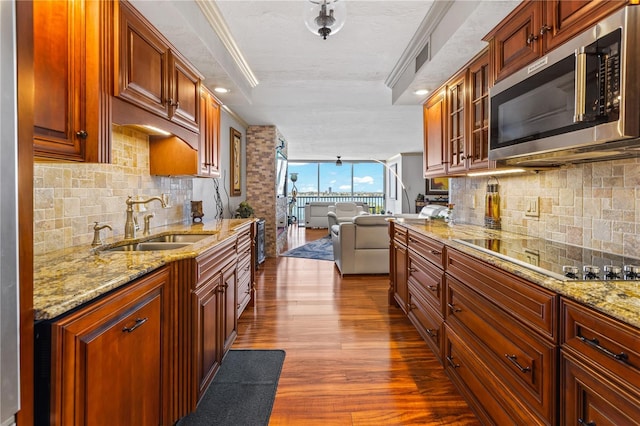 kitchen featuring black electric stovetop, dark wood-style flooring, a sink, backsplash, and stainless steel microwave