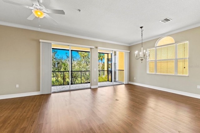 empty room with wood finished floors, visible vents, and crown molding