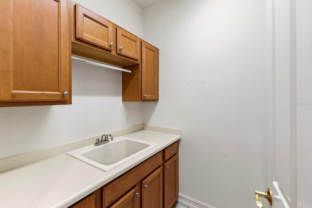 kitchen featuring light countertops, brown cabinets, and a sink