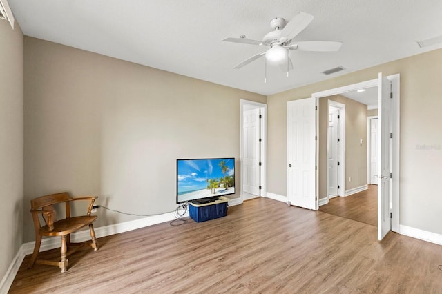 interior space with light wood finished floors, baseboards, visible vents, and a ceiling fan