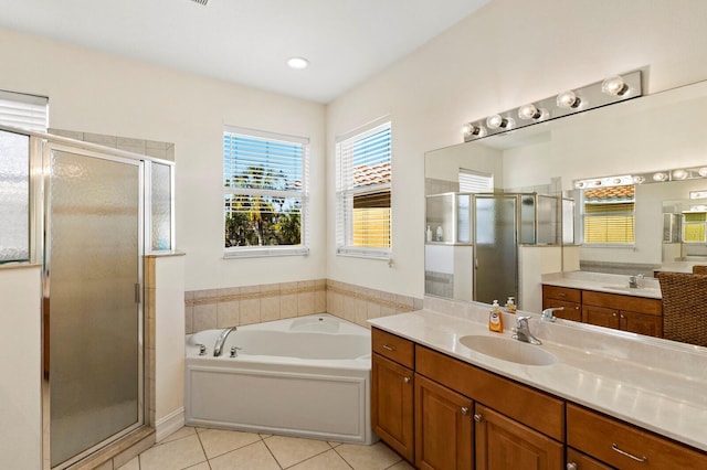 bathroom featuring tile patterned flooring, a sink, a shower stall, and a bath