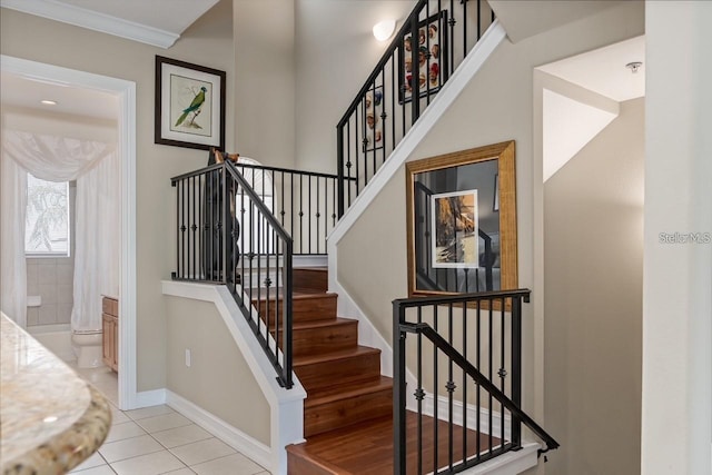 stairway with ornamental molding, tile patterned flooring, and baseboards