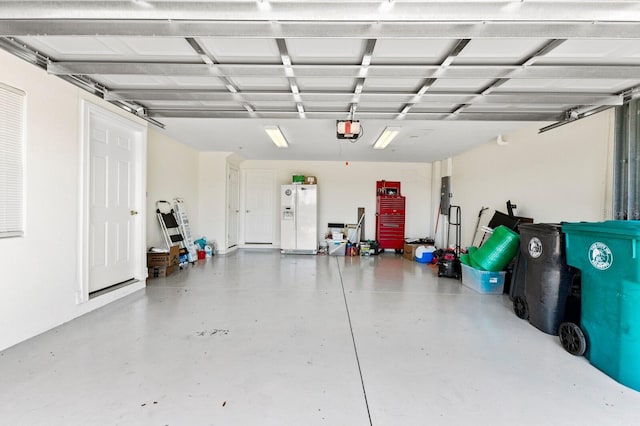 garage with white fridge with ice dispenser and a garage door opener