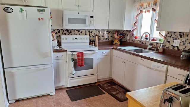 kitchen featuring white appliances, a sink, and white cabinets