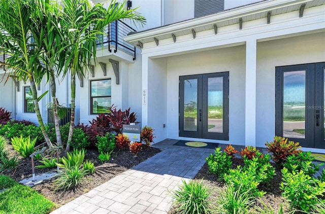 entrance to property featuring french doors and stucco siding