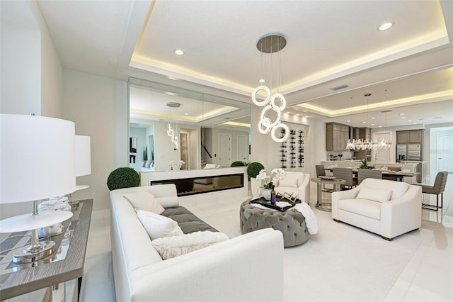 living area with light tile patterned floors, a tray ceiling, stairs, and recessed lighting