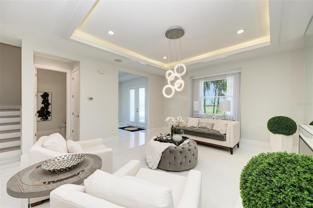 living area featuring baseboards, a raised ceiling, stairway, french doors, and recessed lighting