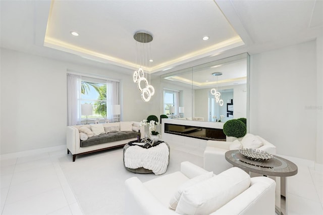 living area with recessed lighting, a raised ceiling, baseboards, and light tile patterned floors