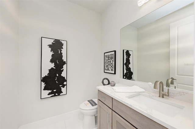 bathroom featuring toilet, tile patterned flooring, baseboards, and vanity