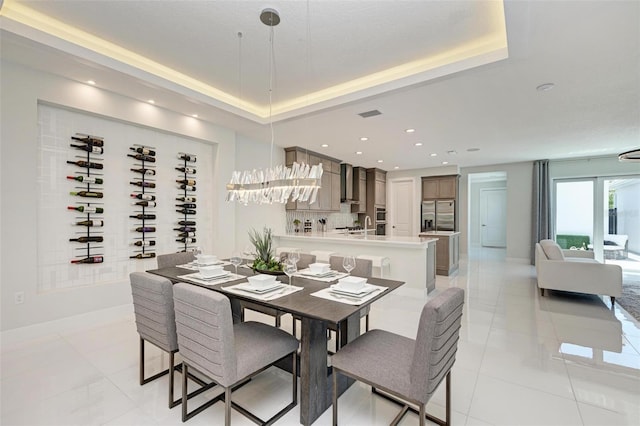 dining area featuring a tray ceiling, light tile patterned flooring, baseboards, and recessed lighting