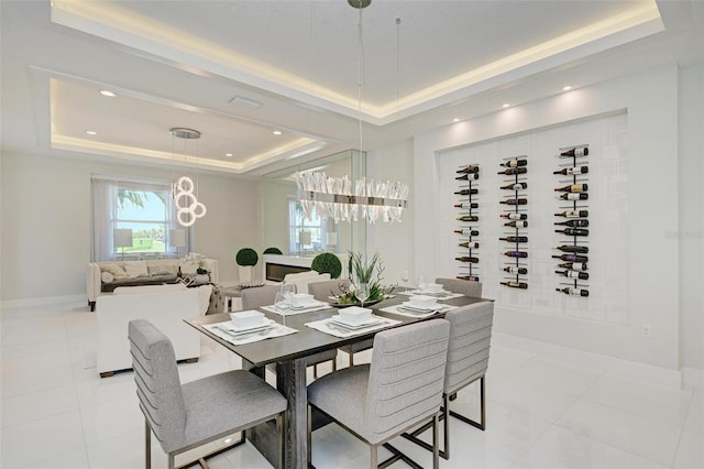 dining room with light tile patterned floors, a tray ceiling, recessed lighting, and baseboards