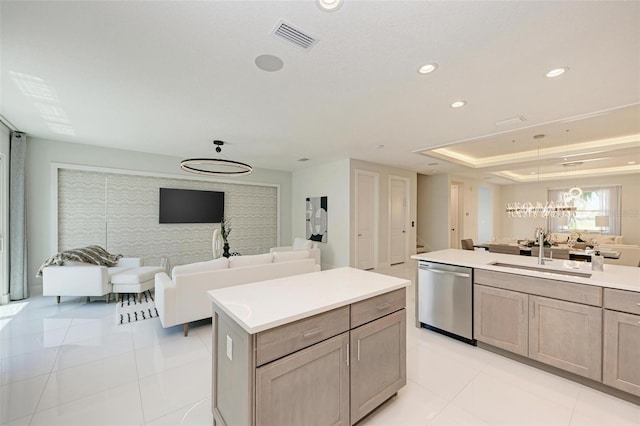 kitchen featuring dishwasher, light countertops, open floor plan, and a sink