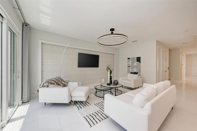 living room featuring an accent wall and light tile patterned flooring