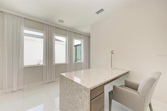 office space with light tile patterned floors, baseboards, and visible vents