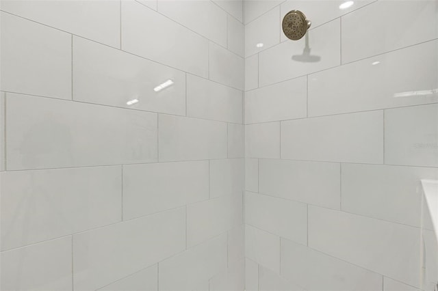 interior details featuring a tile shower