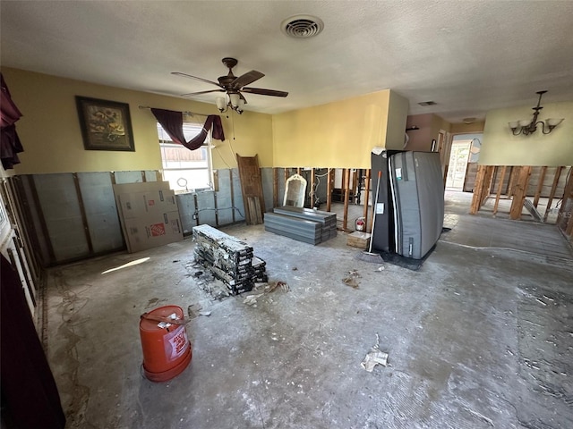 misc room with a textured ceiling, ceiling fan, and visible vents