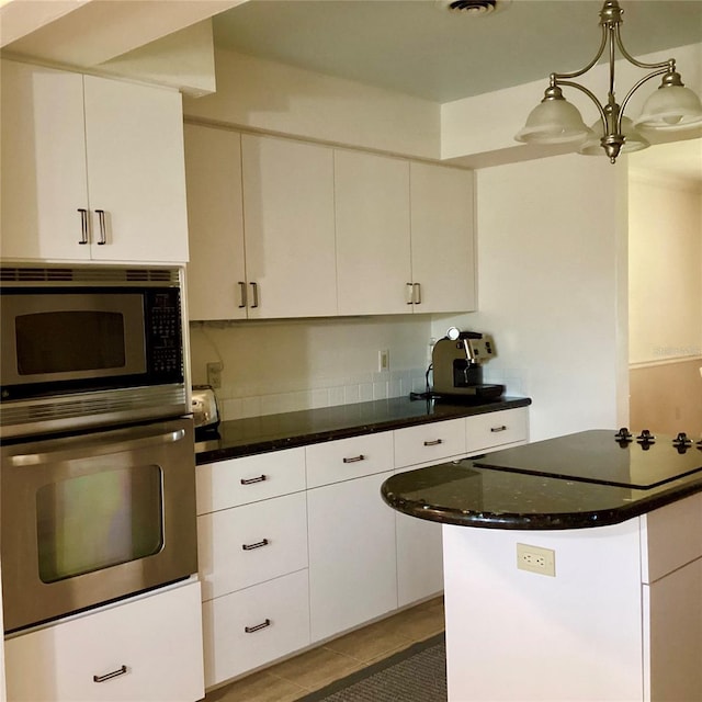 1428 Pine Island Ct, Punta Gorda, FL 33950 - kitchen featuring tile patterned floors, white cabinetry, stainless steel appliances, and decorative light fixtures