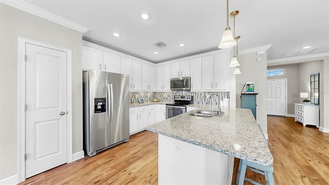 kitchen featuring a sink, stainless steel appliances, visible vents, and crown molding