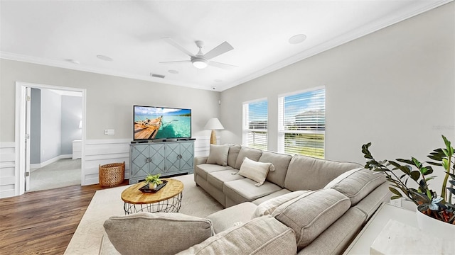 living area with ceiling fan, visible vents, wood finished floors, and crown molding