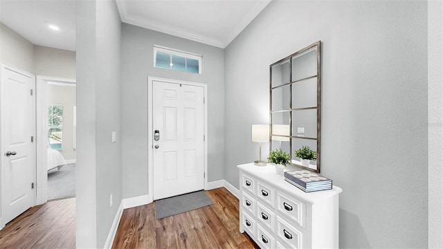 entrance foyer featuring ornamental molding, baseboards, and wood finished floors