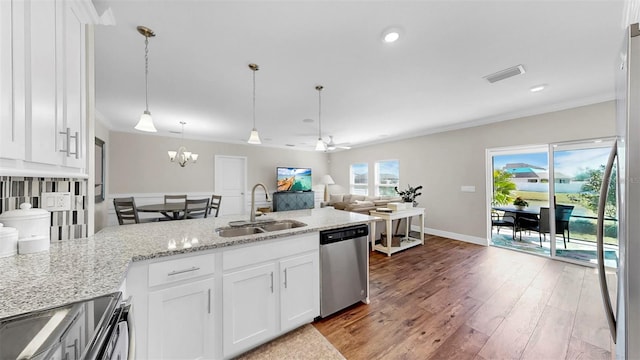 kitchen featuring ornamental molding, wood finished floors, white cabinets, stainless steel appliances, and a sink