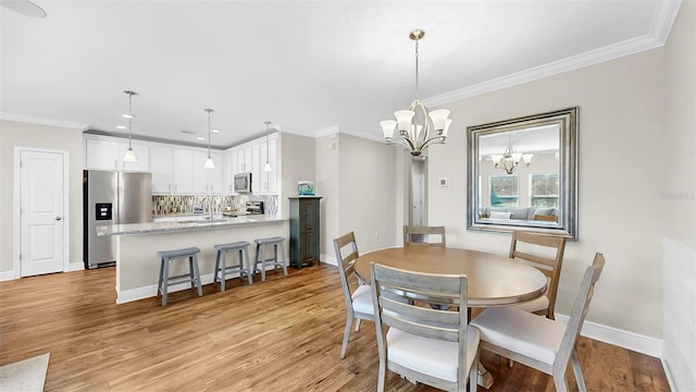 dining space featuring an inviting chandelier, baseboards, light wood-type flooring, and ornamental molding