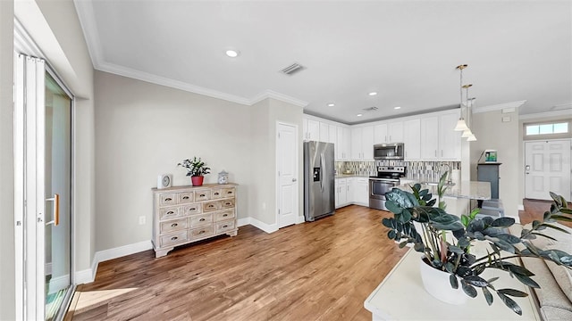 kitchen with stainless steel appliances, visible vents, light wood-style flooring, and crown molding