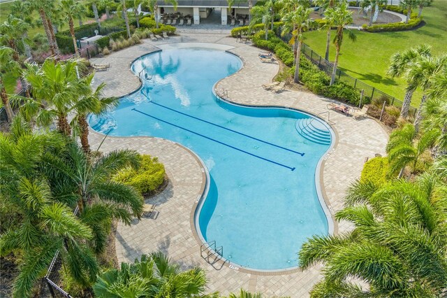 community pool featuring a yard, a patio, and fence