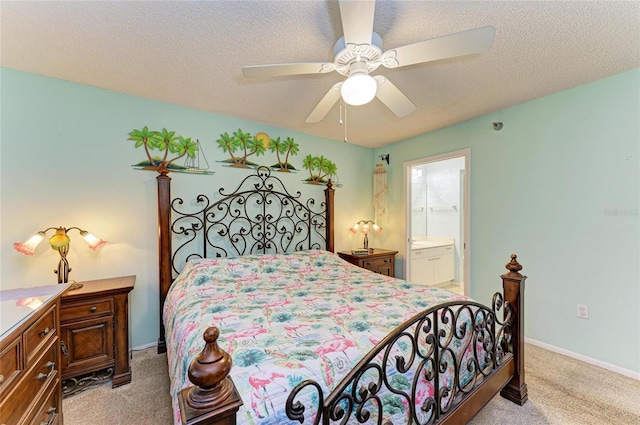 bedroom featuring a textured ceiling, ensuite bathroom, light colored carpet, a ceiling fan, and baseboards
