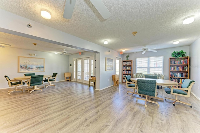 dining area with light wood-style floors, french doors, and a ceiling fan