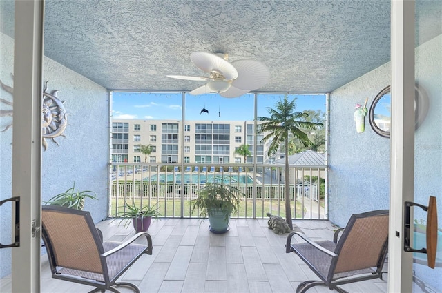 sunroom / solarium featuring ceiling fan