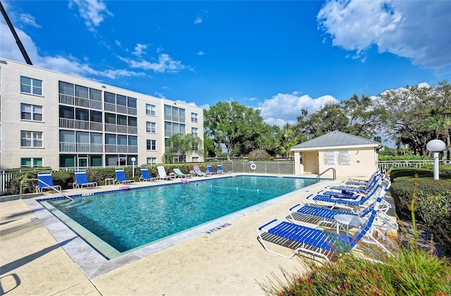 community pool featuring fence and a patio