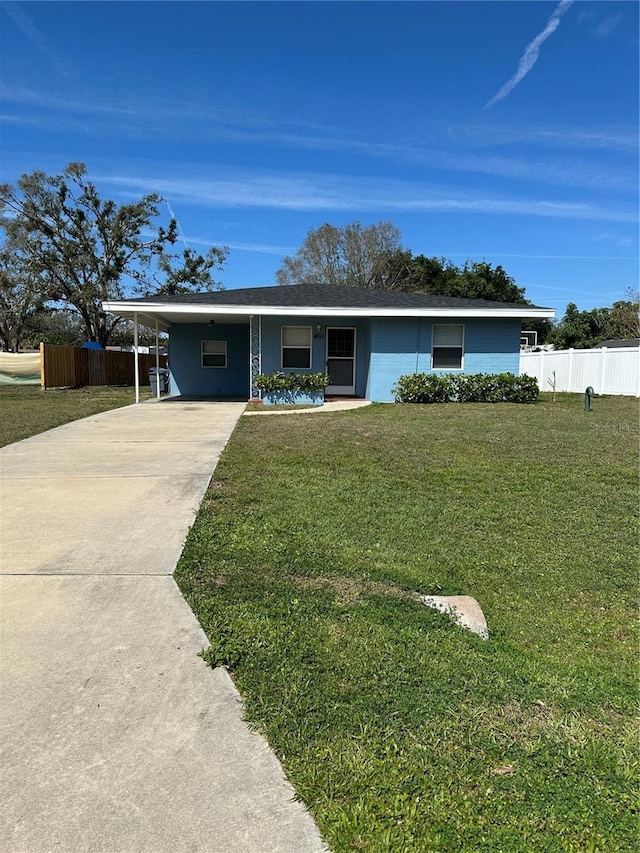 ranch-style home with concrete driveway, a front lawn, fence, and an attached carport