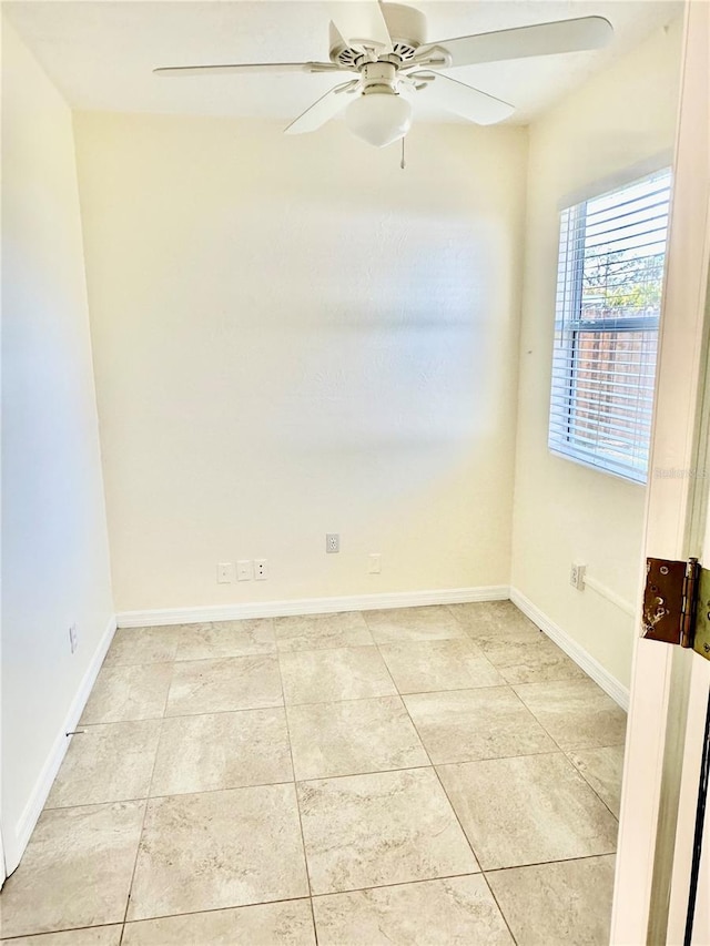 unfurnished room with ceiling fan, light tile patterned flooring, and baseboards