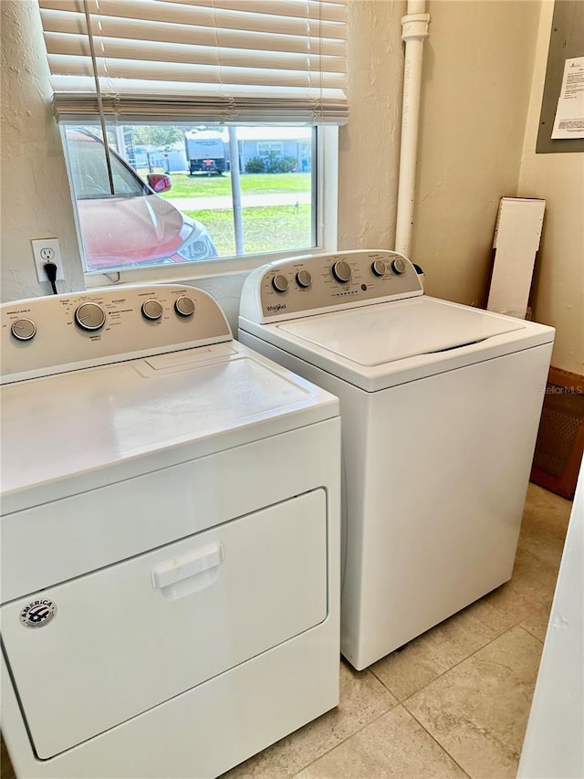 laundry room featuring a textured wall, laundry area, and washing machine and clothes dryer