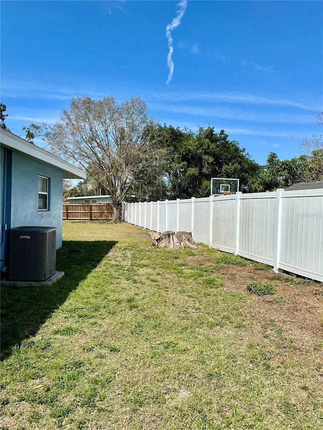 view of yard with a fenced backyard and central air condition unit