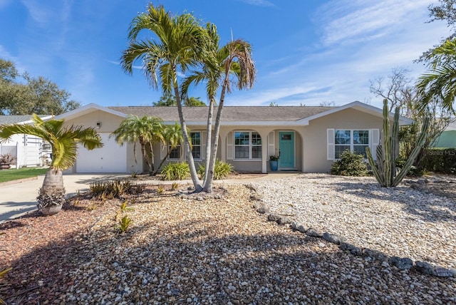 ranch-style house featuring driveway, an attached garage, and stucco siding