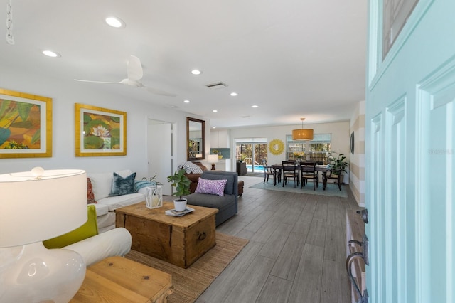 living room with ceiling fan, visible vents, wood finished floors, and recessed lighting