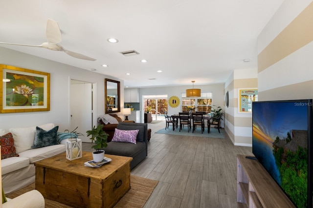 living room featuring recessed lighting, a ceiling fan, baseboards, visible vents, and light wood finished floors