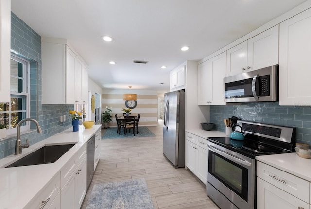 kitchen featuring light countertops, visible vents, appliances with stainless steel finishes, white cabinets, and a sink