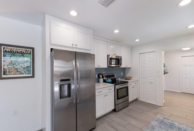 kitchen featuring light countertops, visible vents, decorative backsplash, appliances with stainless steel finishes, and white cabinetry