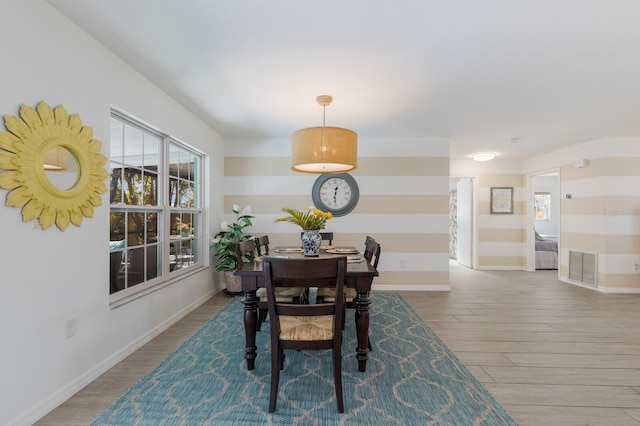 dining area featuring visible vents, baseboards, and wood finished floors