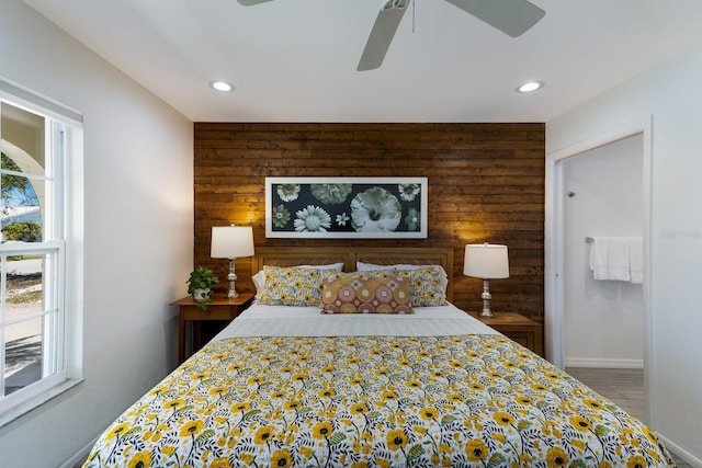 bedroom featuring wood walls, multiple windows, and recessed lighting