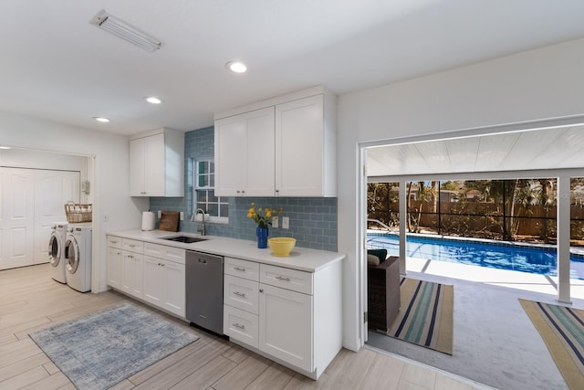 kitchen featuring visible vents, white cabinets, light countertops, washer and dryer, and stainless steel dishwasher