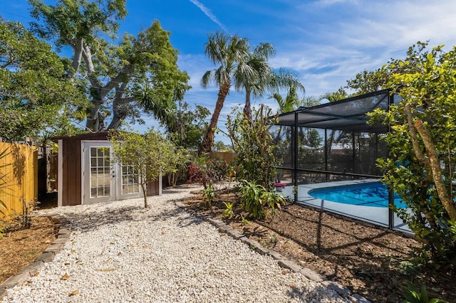 outdoor pool with a fenced backyard and an outdoor structure