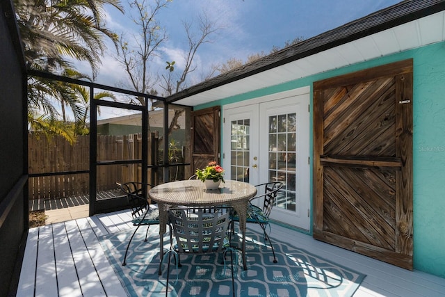 wooden deck featuring outdoor dining space, fence, and french doors