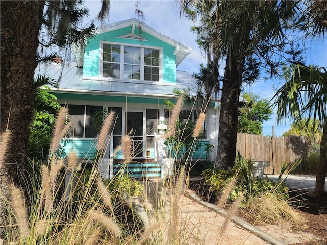 view of front of property featuring a sunroom and fence