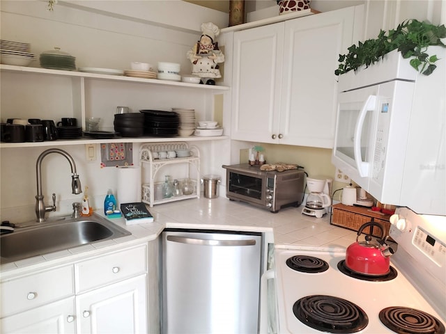 kitchen featuring white appliances, white cabinets, tile countertops, open shelves, and a sink