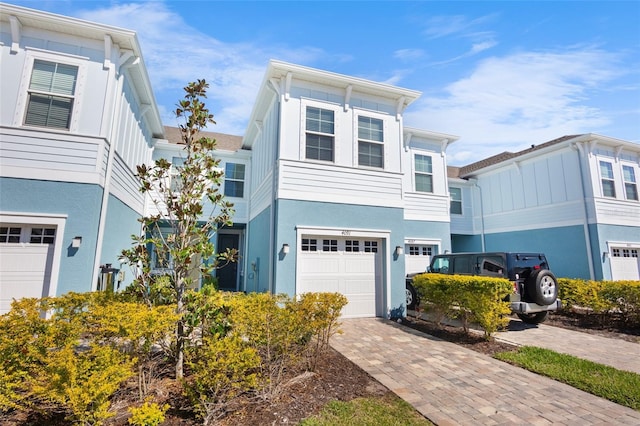 view of front of property featuring decorative driveway, an attached garage, and stucco siding